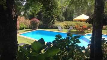 Una piscina cubierta, una piscina al aire libre de temporada, sombrillas