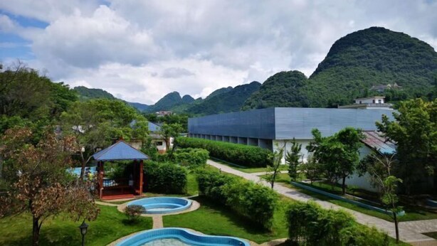 Un complexe hôtelier doté d’une piscine, d’un belvédère et offrant une vue sur de luxuriantes montagnes verdoyantes.