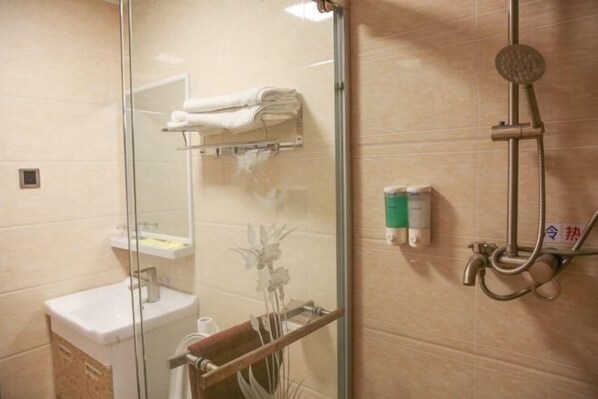 A bathroom with a glass shower enclosure, a sink, a towel rack, and a toilet.