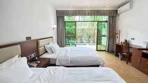 Une chambre d’hôtel avec deux lits, un bureau, une chaise et une vue sur la piscine.