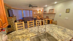 A kitchen with granite countertops, a stainless steel sink, wooden chairs, and a dining area with a table and chairs. - Fernie ON THE MOUNTAIN luxury 2 bedrooms 3 beds (1 king, 2 queen), 2 baths.  (Fernie)