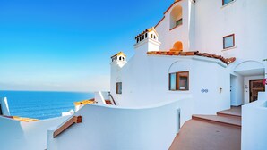 Un edificio blanco con un balcón curvo que da al mar.