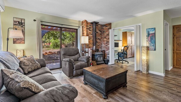 A living room with a sofa, a chair, a coffee table, a fireplace, and a view of the outdoors. - Recently acquired property that's a work in progress (Sedona)