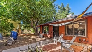 A wooden house with a patio, outdoor seating, and a covered area. - Recently acquired property that's a work in progress (Sedona)