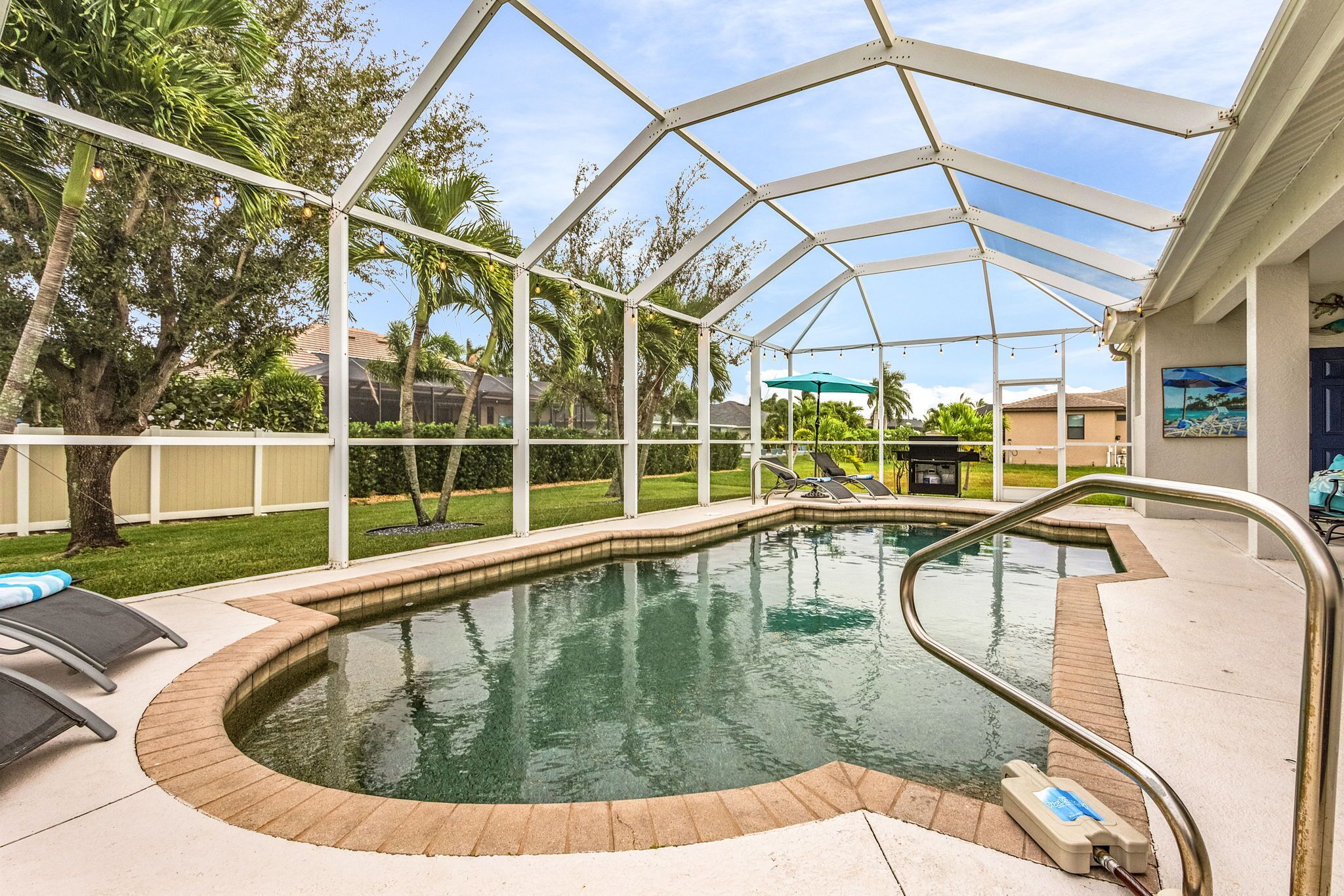 Una piscina techada con vistas despejadas de la vegetación circundante y un área de patio con sillones de descanso.