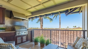 A covered patio with a grill, seating area, and potted plants. - Luxury Stay w/ Private Beach Club, Hilton Pool Passes, Sunset Views (Waimea)