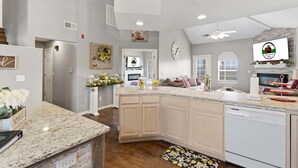 A spacious kitchen with granite countertops, a dishwasher, and a large island. - Golf Course Escape • 3BR Legacy Condo w/ Fireplace & Sunroom (Branson)