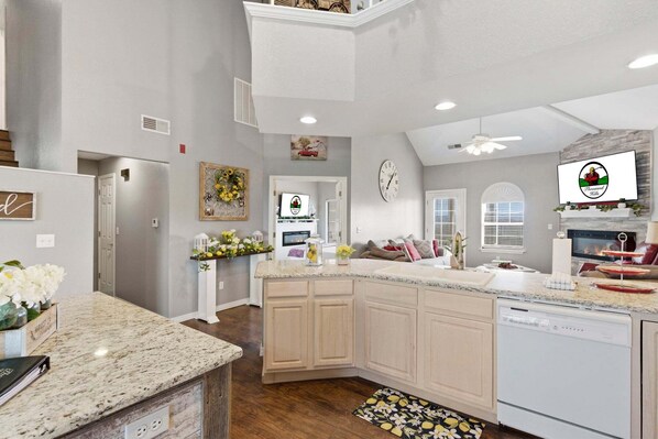 A spacious kitchen with granite countertops, a dishwasher, and a large island. - Golf Course Escape • 3BR Legacy Condo w/ Fireplace & Sunroom (Branson)