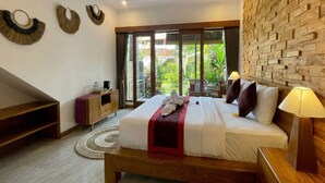 A bedroom with a bed, bedside tables, a wooden headboard, a wall-mounted light, and a view of greenery outside. - Sari Murni (Ubud)