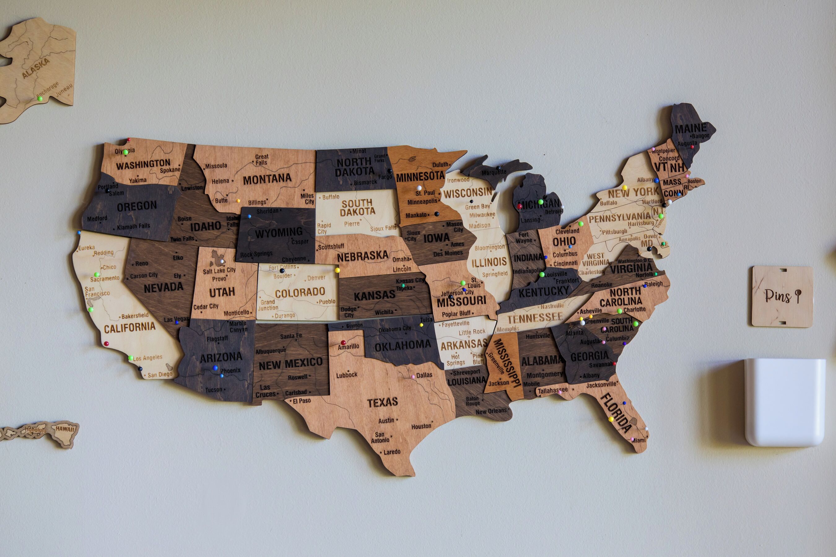 A wooden map of the United States with state names and major cities marked.