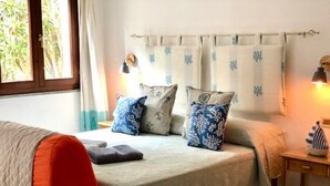 A bedroom with a bed, pillows, a bedside table, and a window. - Sweet Home Mare Li FERULI (Trinita d'Agultu)