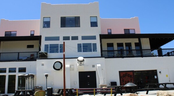 Un edificio de varios pisos con fachada plana, ventanas grandes y una puerta negra.