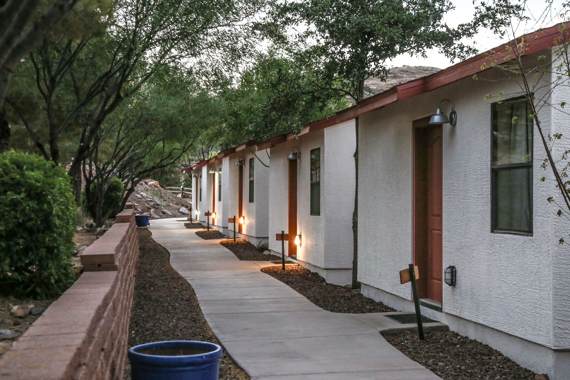 A row of single-story buildings with individual entrances, each with a small porch and a door.