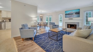 A modern living room with a fireplace, comfortable seating, and a dining area. - 276 Evian: Newly renovated single story unit with golf course views and tennis court access! (Hilton Head Island)
