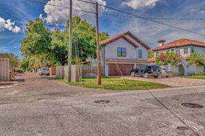 Una calle residencial con casas, un garaje y automóviles estacionados.