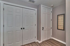 A hallway with two white double doors and a framed family rules poster on the wall. - South Tampa Private Gem Attached to $Million Home (Tampa)