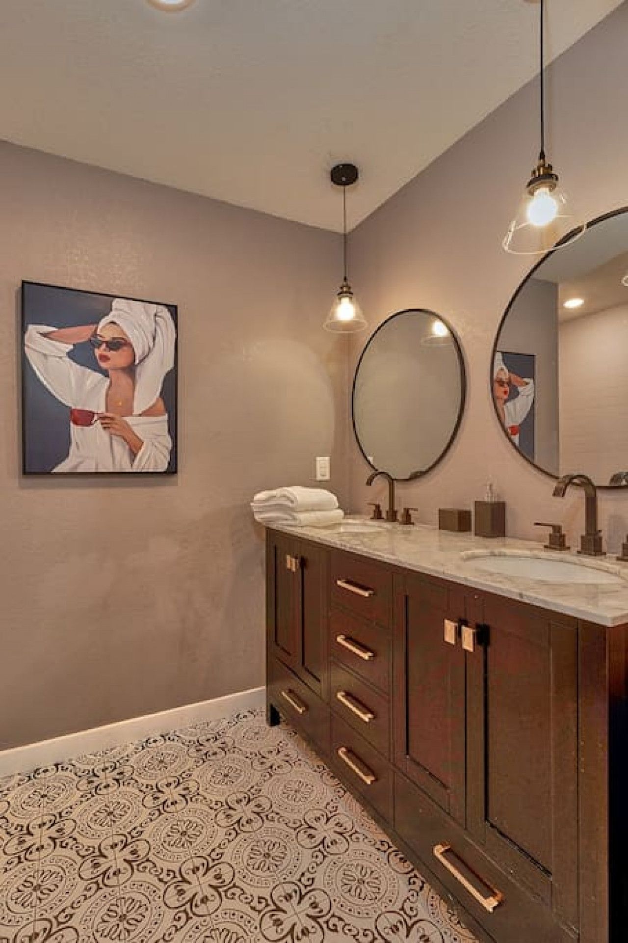 A modern bathroom with a large mirror, a double sink vanity, and a patterned floor.