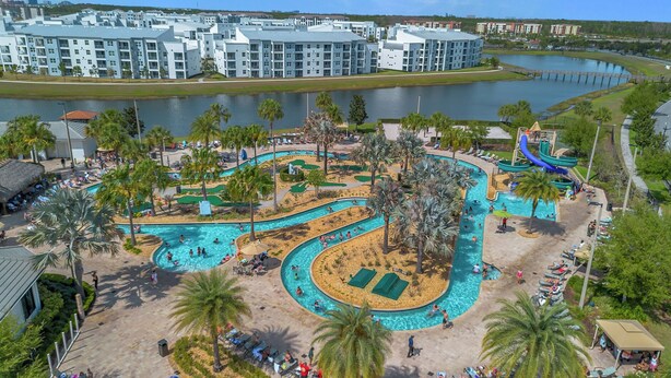 A resort with multiple swimming pools, palm trees, and a water slide.