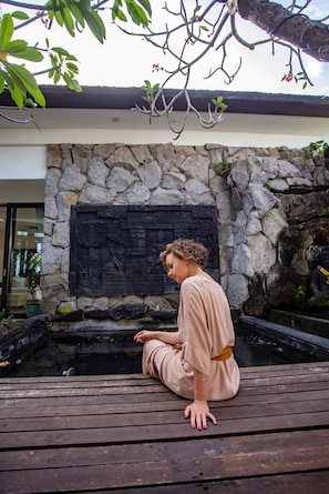 Guests can sit on the deck and gaze out at the serene pond surrounded by lush greenery.