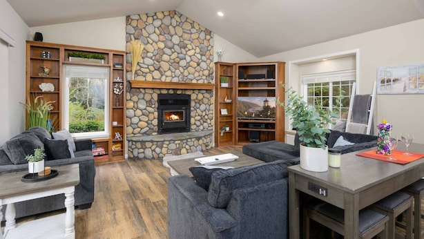 A cozy living room with a stone fireplace, built-in shelving, and comfortable seating. - New Listing! Beautiful well appointed Woahink lake area home w/ gas grill and fire pit (Florence)