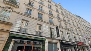 Um edifício de vários andares com um café chamado 'CAEPUS' no andar térreo.