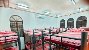 Un dormitorio con literas, una ventana y un equipo de aire acondicionado.