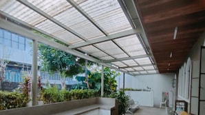 Un espacio interior amplio con techo alto, ventanas grandes y un banco de hormigón.