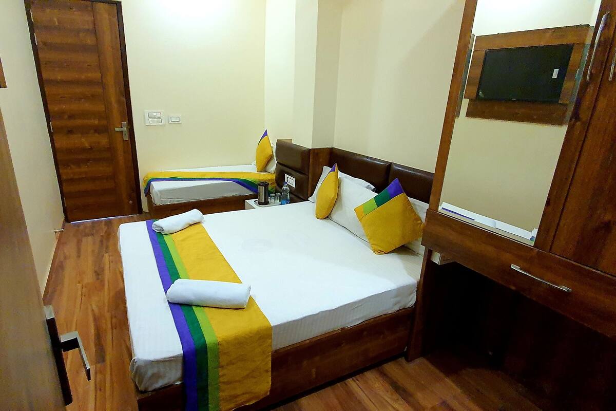 Una habitación de hotel con una cama de madera, una mesita de noche y un espejo.