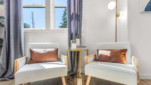 Two armchairs with cushions, a small round table with a candle and books, and a floor lamp. - Ringo's Sweet Suite - 84 Walkscore!! (Seattle)
