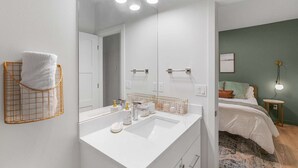 A modern bathroom with a large mirror, white sink, and gold-framed towel rack. - Kurt's Sweet Suite - 84 Walkscore!! (Seattle)