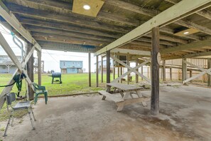 A covered outdoor area with picnic tables and chairs, wooden beams, and a concrete floor. - Ocean Views: Second-Row Surfside Beach House (Freeport)
