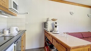 A compact kitchen with a microwave, toaster, and coffee maker on a countertop. - Spacious apartment in Les Menuires, 3 rooms, at the foot of the slopes (Les Menuires)