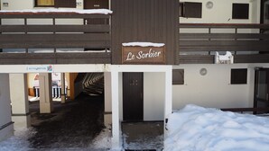 A building with a sign reading "Le Sorbier" and a staircase leading to an upper level.