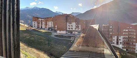 A ski resort with a ski lift, buildings, and mountains in the background.