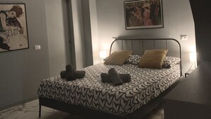 Un dormitorio con cama, un cuadro y una lámpara en el techo.