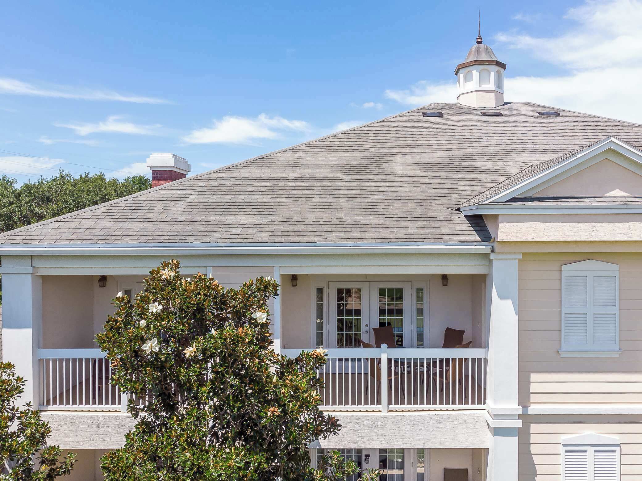 A two-story house with a covered porch and a chimney.