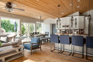 A spacious kitchen with wooden cabinets, a dining area with chairs, and a large window providing natural light. - Old Town Farm-to-Table: Harvest, Pool, Spa (Scottsdale)