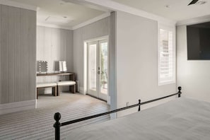 A modern bedroom with a large bed, a bench, and a vanity with lights. - Old Town Farm-to-Table: Harvest, Pool, Spa (Scottsdale)
