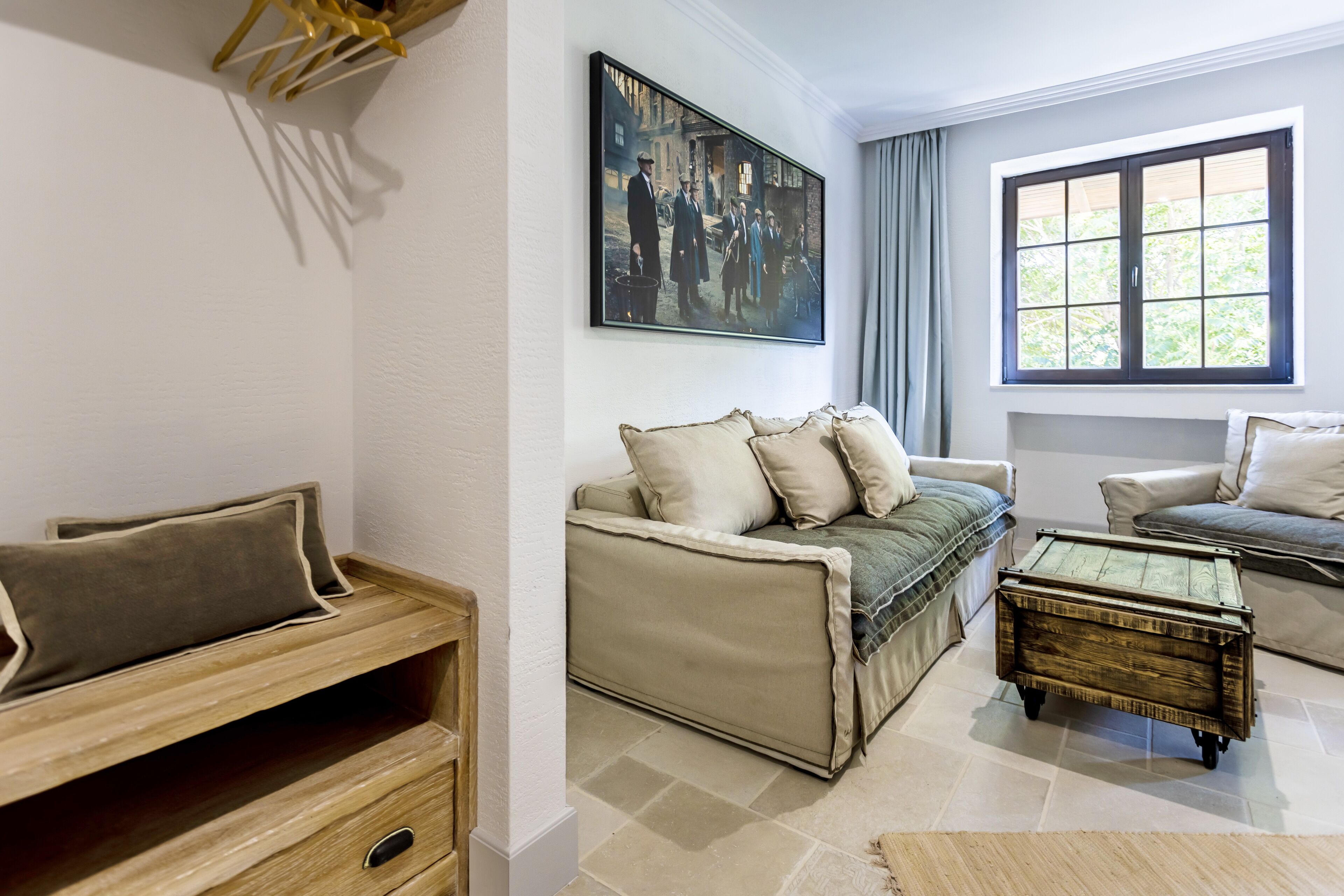 A living room with a sofa, a coffee table, and a painting on the wall.