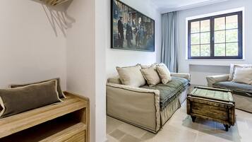A living room with a sofa, a coffee table, and a painting on the wall.