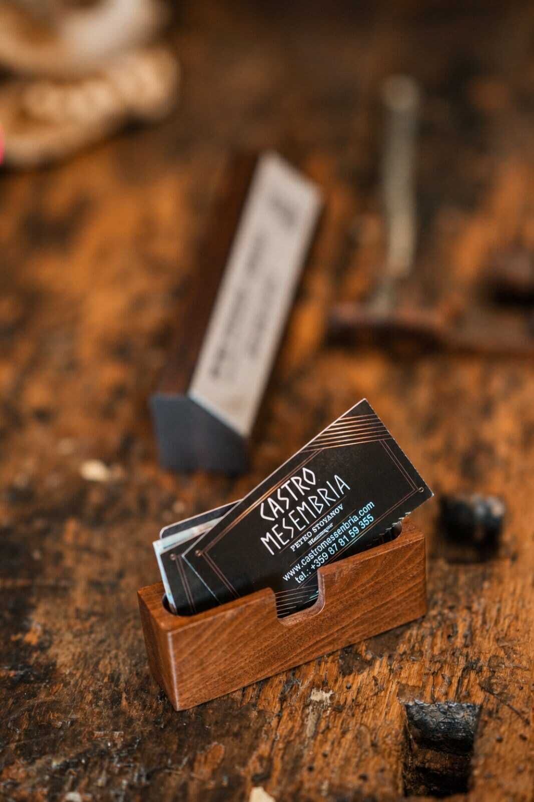 Una caja de madera con una tarjeta de presentación que dice 'CASTRO MESEMBRIA' sobre una superficie de madera.