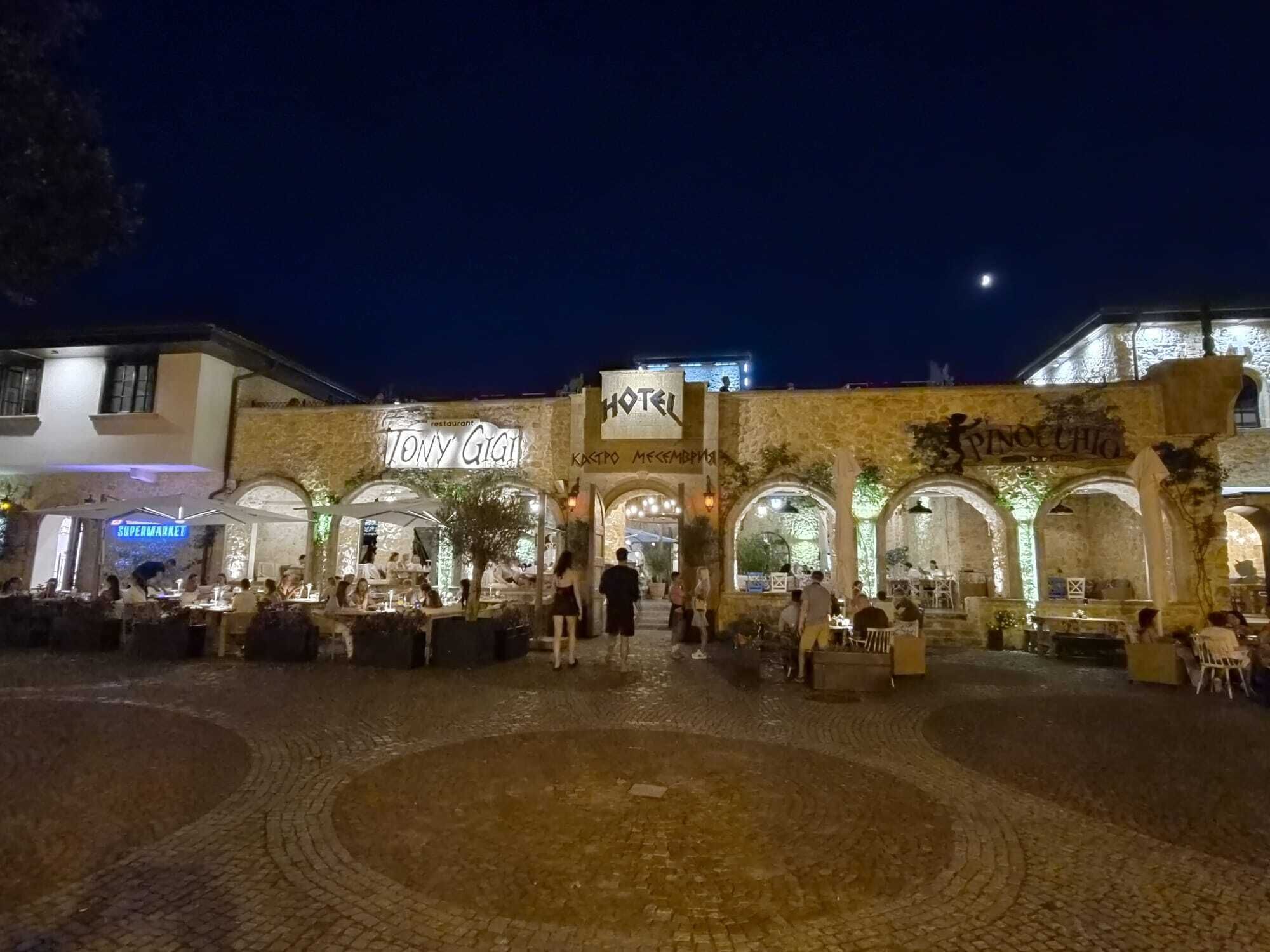 A hotel with a restaurant named 'Tony Gigio' and a sign for 'PINO CHIO' in the background.