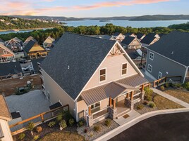 A residential area with houses featuring gabled roofs and a view of a lake.