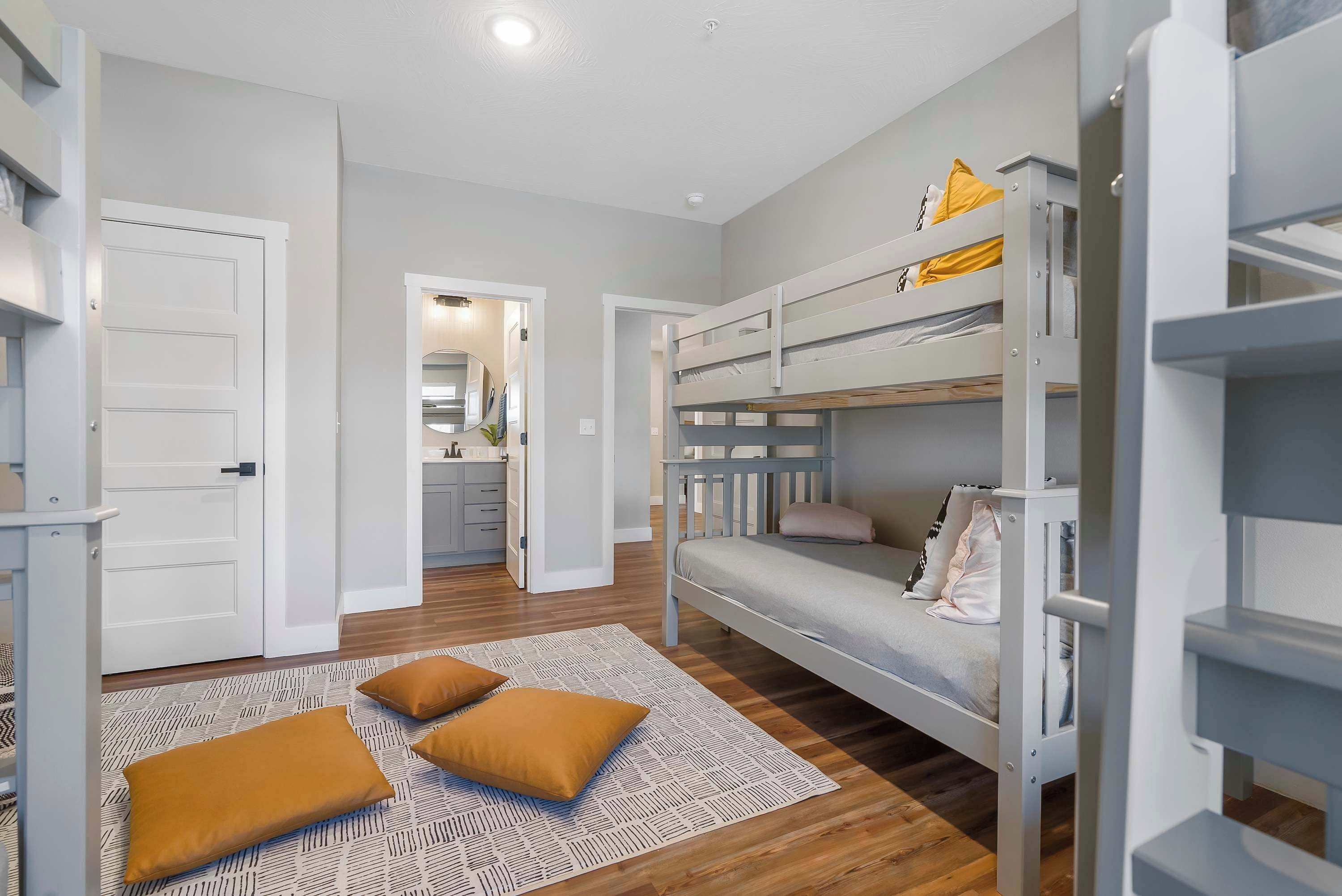 A bedroom with bunk beds, a patterned rug, and a white door.