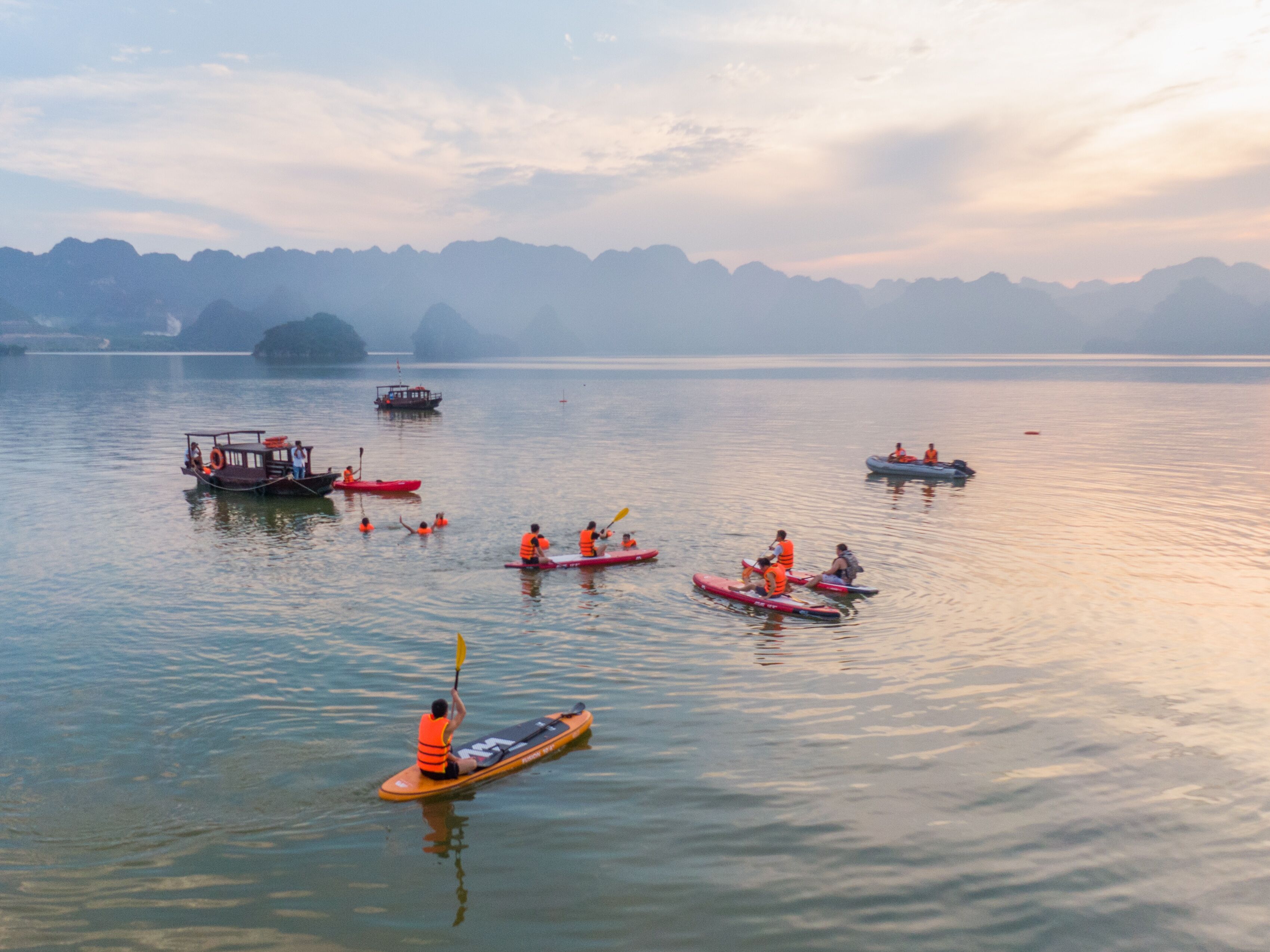 Un lago tranquilo con varias kayaks y un pequeño bote.