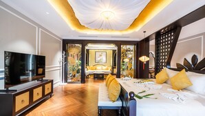 Une chambre d’hôtel moderne dotée d’un grand lit, d’une télévision et d’un coin salon avec un canapé et une table basse.
