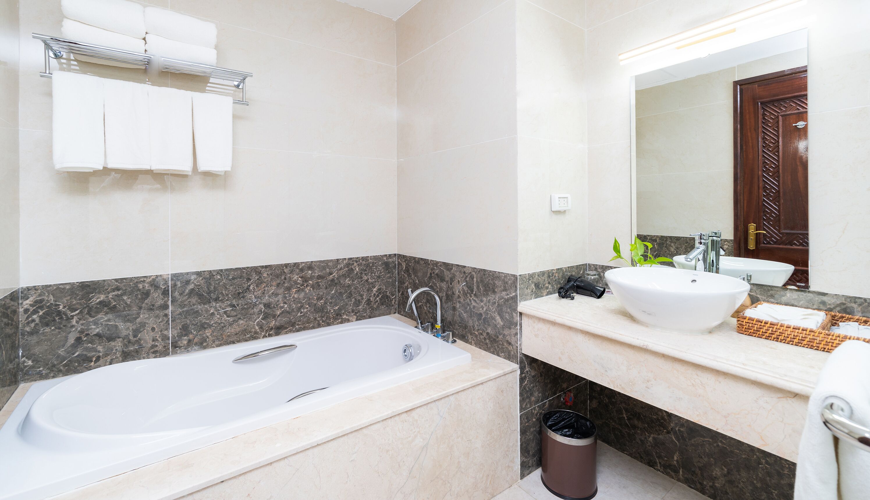 Ein modernes Badezimmer mit einer Badewanne, einem Waschbecken und einem Spiegel.