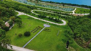 Vista aérea de un parque con senderos, una zona central circular y una masa de agua.