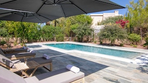 A poolside area with lounge chairs and an umbrella. - Phaedrus Living: Amorosa 13 Beachside Villa (Neo Chorio)