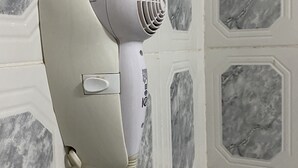 A hair dryer mounted on a wall with a marble-like pattern. - Hotel Itavera (Puerto Iguazú)